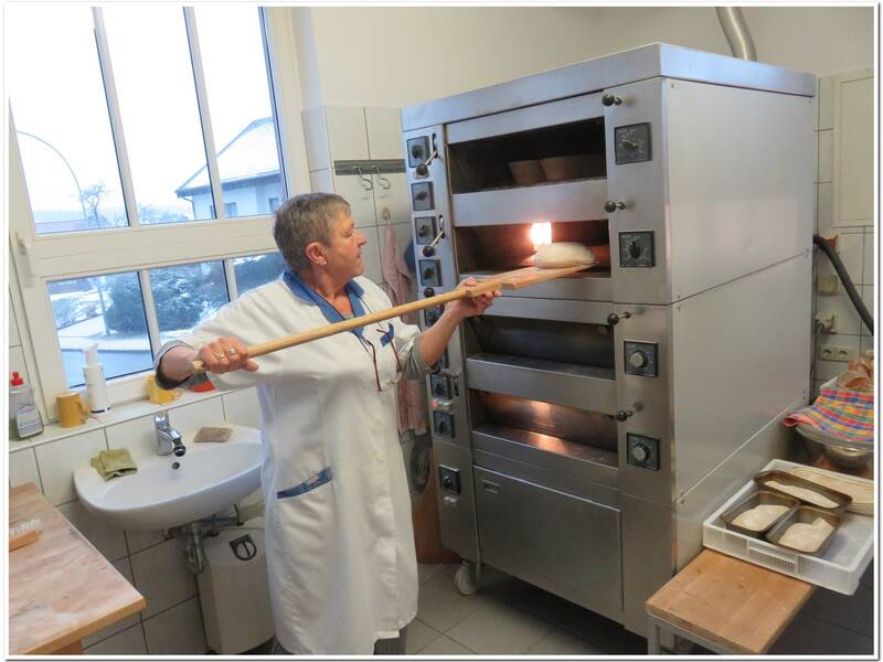 Das Bild zeigt Frau Oser vor dem Brotbackofen im Backhaus in Herrenzimmern.